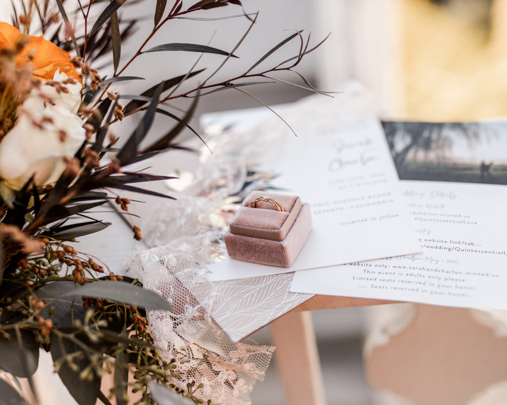 Photo of rings and invitations on a wedding day.