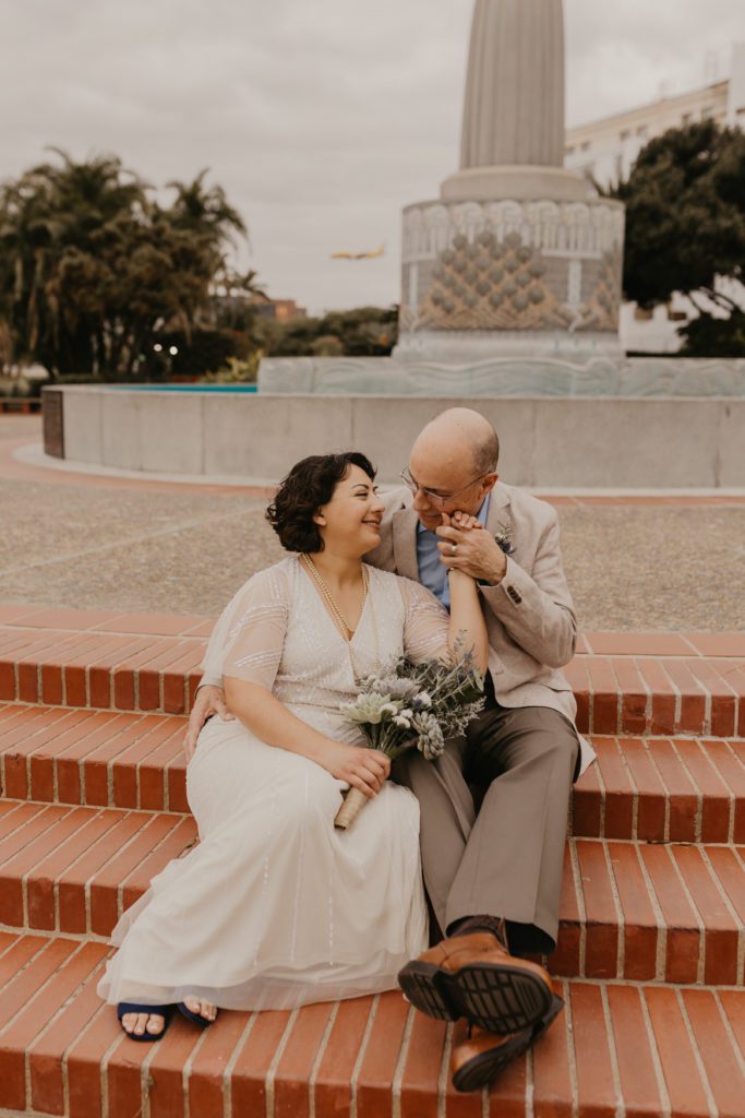 Couple sitting on steps after eloping at the San Diego County Clerk Office
