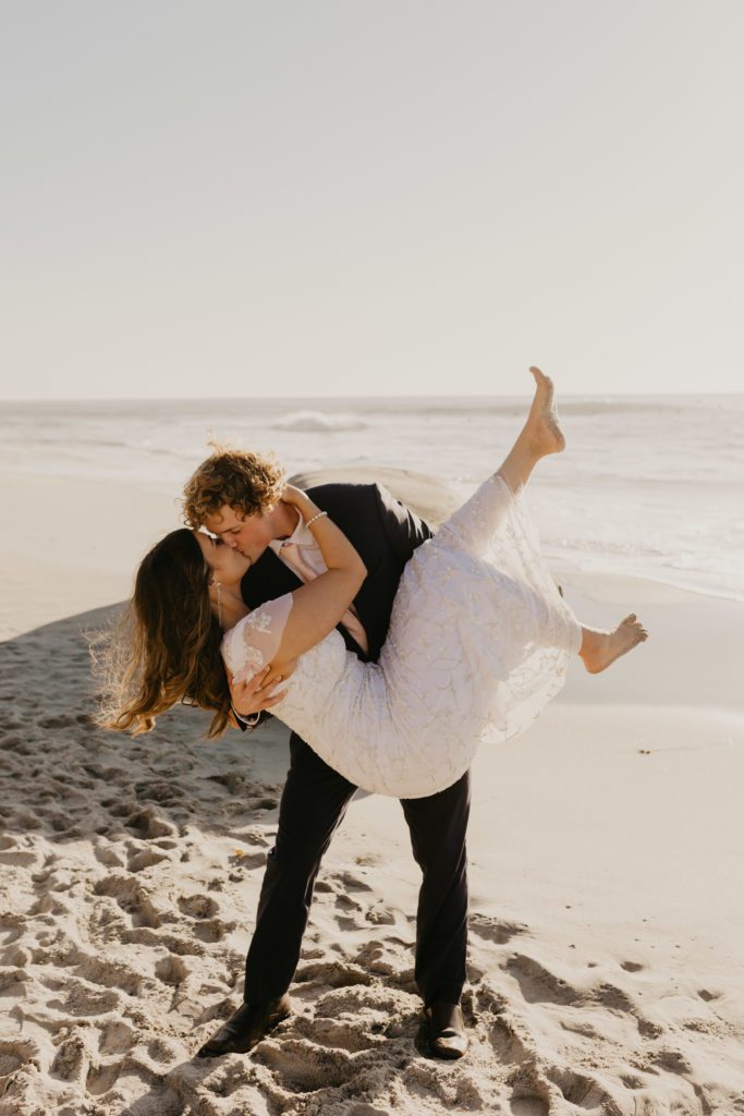 Newlywed couple kissing on the beach