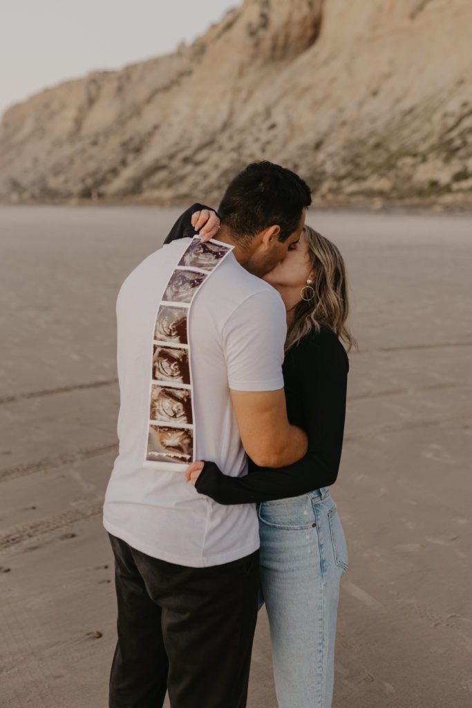 couple kissing and holding an ultrasound