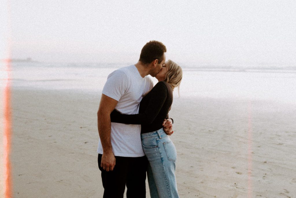 Couple kissing at Blacks Beach in San Diego.